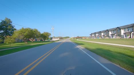 Pov-Conduciendo-Por-Una-Carretera-Pavimentada-A-Través-Del-Borde-De-Un-Pequeño-Pueblo-En-Hills,-Iowa