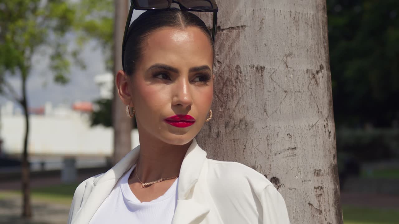 acercamiento facial de una joven bonita en la ciudad con un traje de negocios blanco
