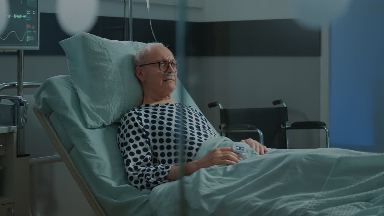 Sick old man staying in hospital ward bed with oximeter