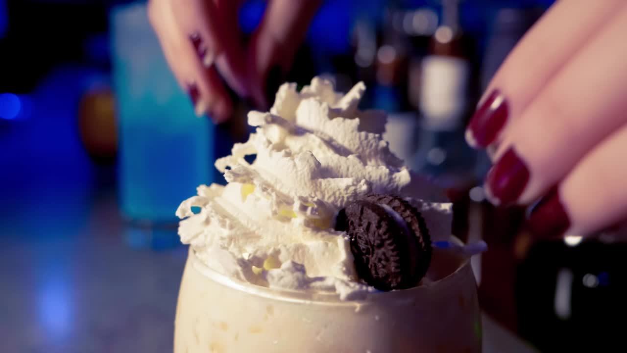 Making a cocktail with wipped cream and oreos in slow motion