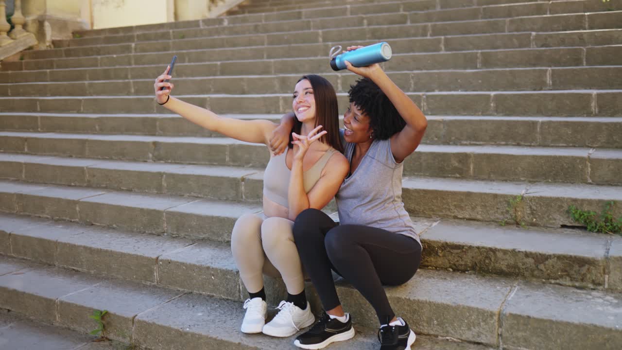 Deux femmes heureuses prenant un selfie sur des escaliers en pierre