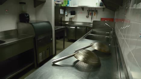 empty kitchen with metal tabletop and clean utensils over it