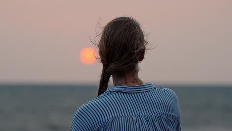 a serene moment in galle, sri lanka, as a woman gazes at the vast ocean during a breathtaking sunset.