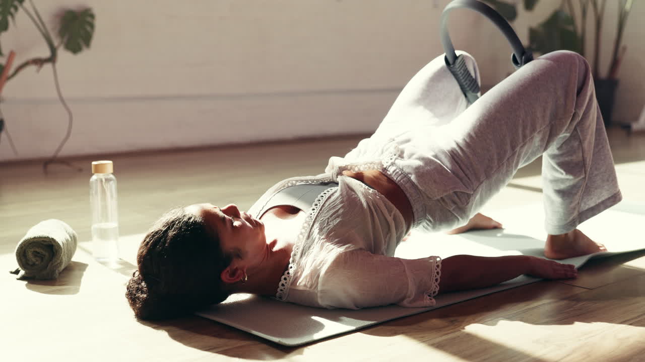 Woman doing pilates bridge pose with ring at home