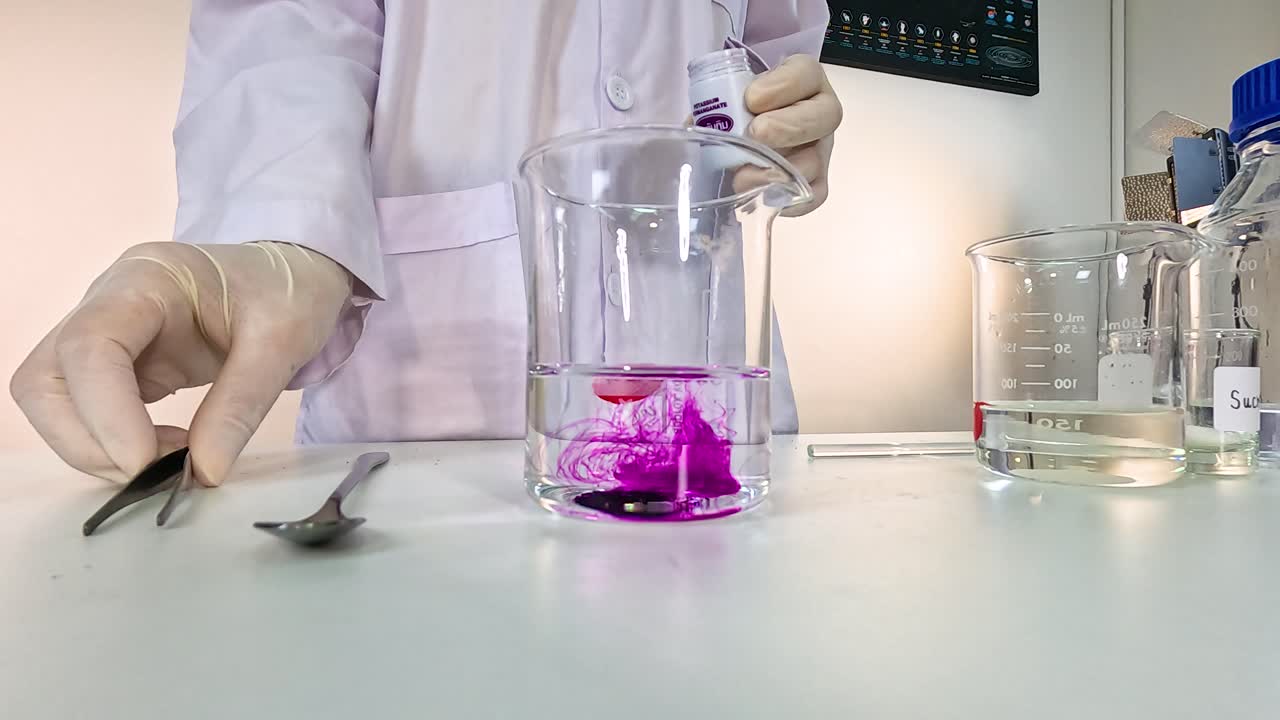 Scientist conducts a color-changing experiment using potassium permanganate in a laboratory setting with controlled lighting