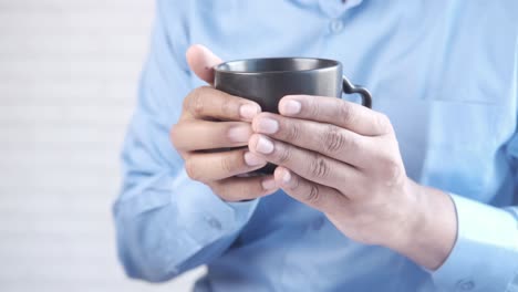 person holding a black coffee cup