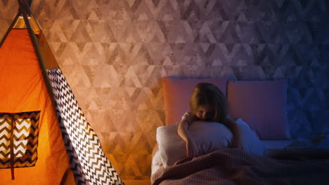 chica cansada abraza almohada sentada en la cama por la tienda en el dormitorio