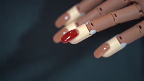 Weibliche-Hände-Bemalen-Mit-Rotem-Lack-Falsche-Nägel,-Die-Auf-Eine-Handprothese-4k-Geklebt-Sind