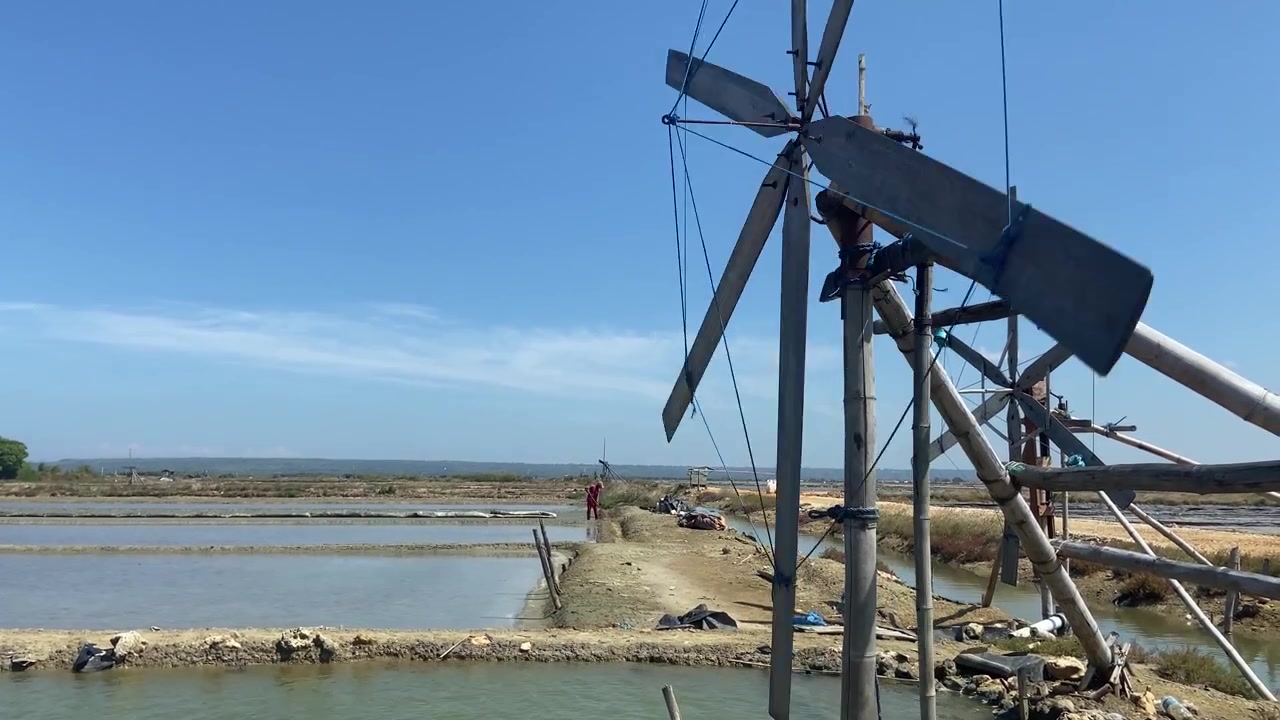 Mulino a vento tradizionale che pompa acqua in una salina.