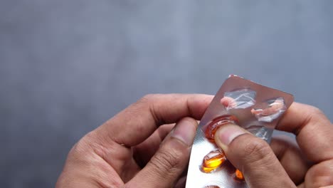 hands opening a blister pack of pills