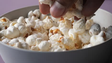 Close-up-of-hand-pick-popcorn-from-a-bowl-,