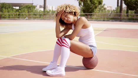 Blond-young-woman-sits-cross-legged-on-ball