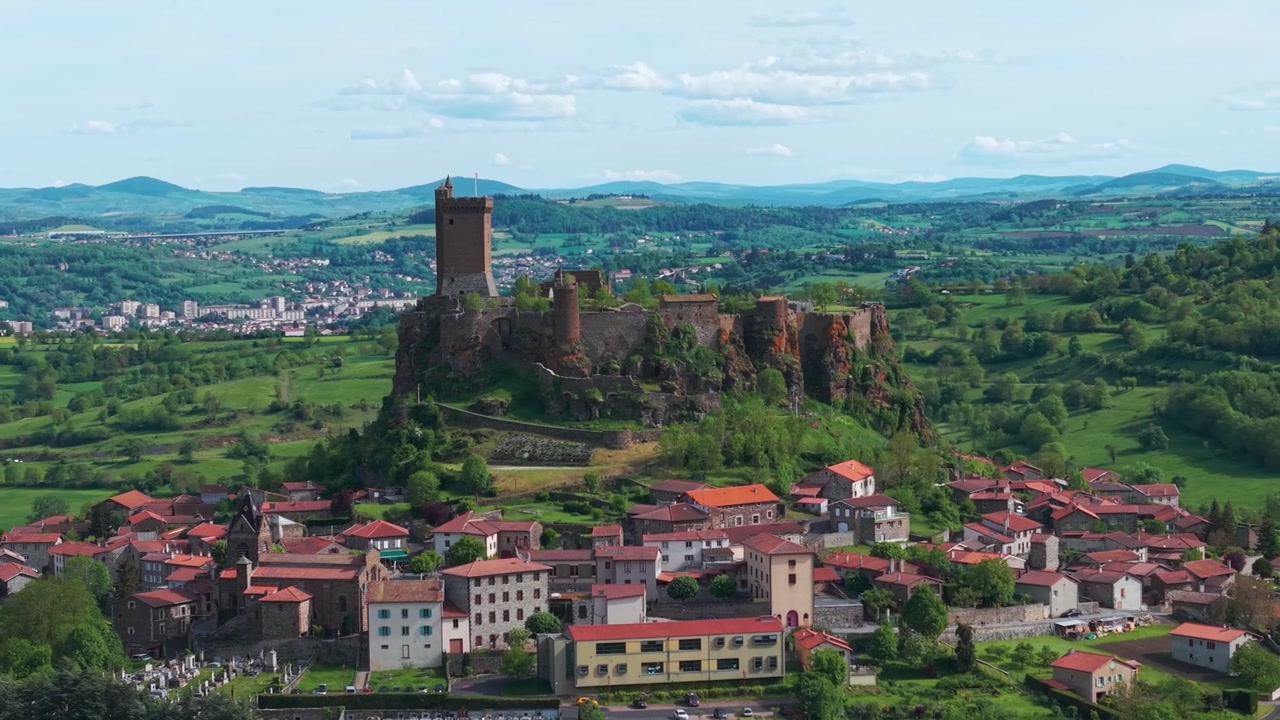 Ripresa aerea intorno alla Fortezza di Polignac nel villaggio medievale di Polignac, vicino a Le Puy-en-Velay, in una bella giornata di primavera, dipartimento dell'Alta Loira, regione Alvernia-Rodano-Alpi, Francia.