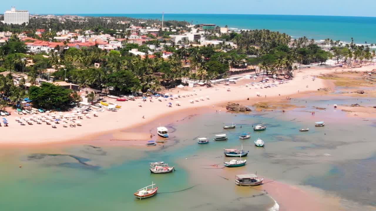 vista aérea de una playa tropical con barcos y palmeras