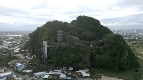 beautiful aerial shot of the green and lush marble mountain in the city da nang, vietnam on a cloudy day