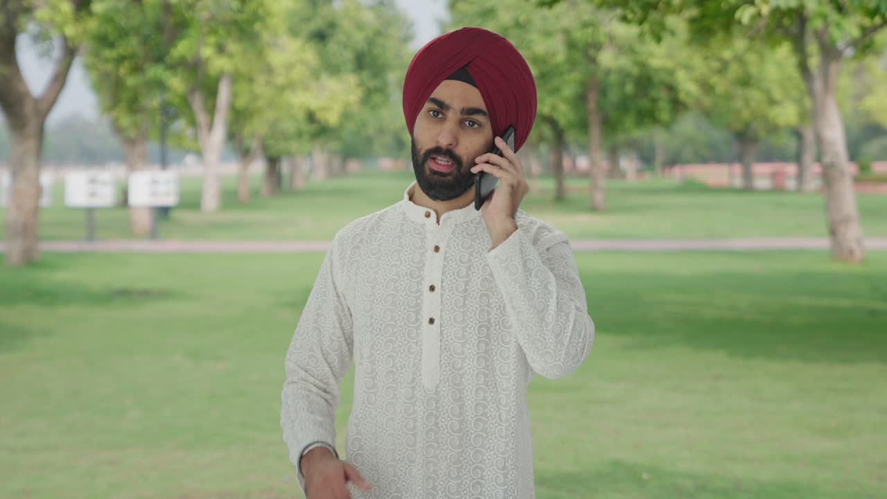Uomo indiano Sikh arrabbiato che urla al telefono nel parco