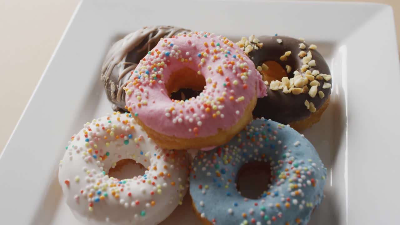 video de rosquillas con glaseado en una placa blanca sobre un fondo blanco