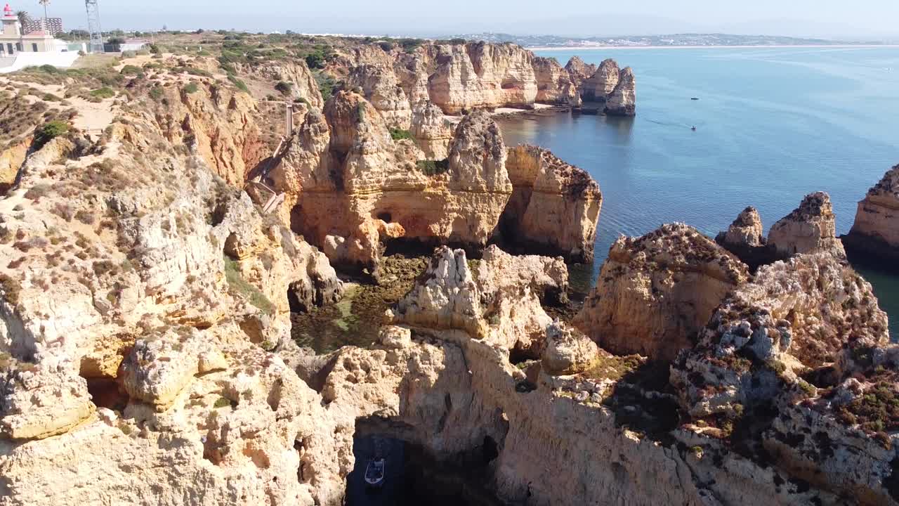 ponta da piedade, lagos, algarve - 바위 절벽, 숨겨진 해변, 맑은 바다가 있는 동굴과 해안선의 공중 드론 보기