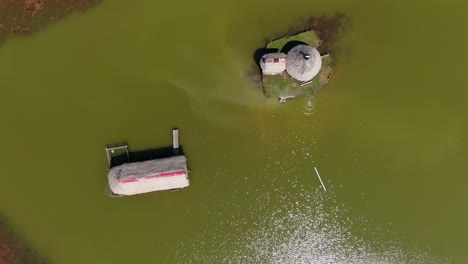 Fascinating-zoom-out-4k-aerial-view-over-the-green-water-of-the-laguna-de-los-milagros-in-Tingo-Maria,-entry-gate-to-the-Amazon-tropical-rain-forest