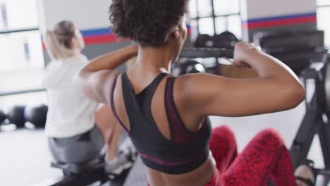 Video-Von-Zwei-Unterschiedlichen-Frauen-Auf-Rudergeräten-Beim-Training-Im-Fitnessstudio