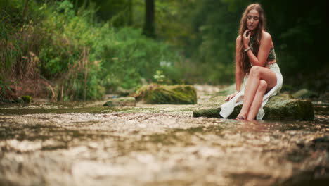 woman seeking inspiration and peace by the river meditating