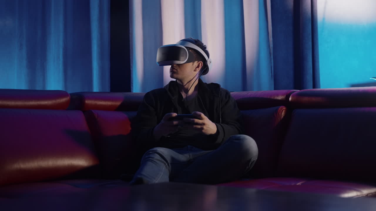 Uomo che gioca a un gioco VR sul divano