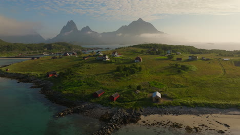 Nubes-Místicas-En-Las-Montañas-Detrás-De-Una-Playa-Tranquila-Con-Un-Velero-Anclado-En-Holdoya,-Noruega