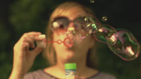 Slow-motion-of-a-girl-blowing-soap-bubbles-with-a-blurred-background