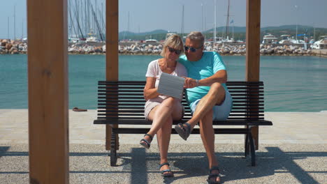 Pareja-De-Familia-Senior-Con-Almohadilla-En-El-Paseo-Marítimo