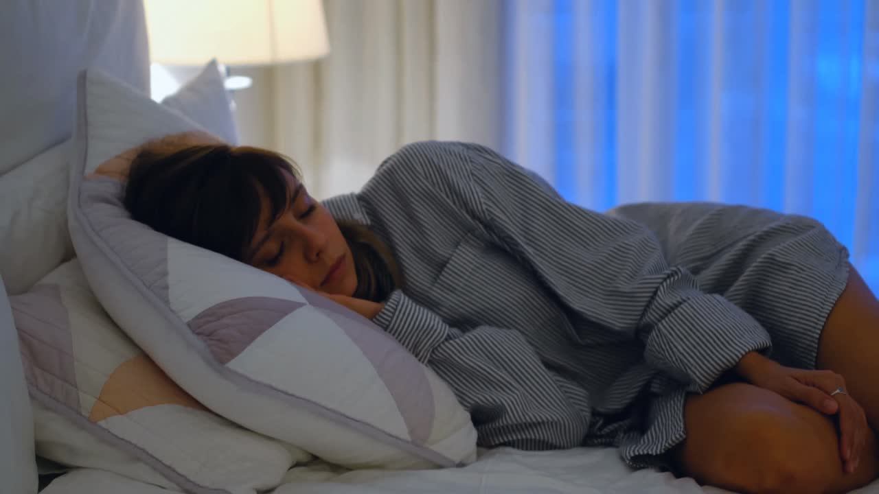 mujer relajándose en la cama en el dormitorio 4k