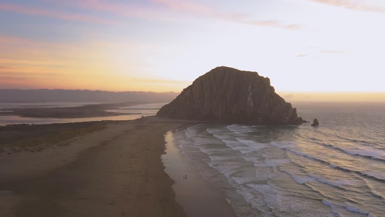 Morro Bay - California, USA. Cinematic aerial pull back at sunset besides shoreline. Filmed on DJI Mavic Pro