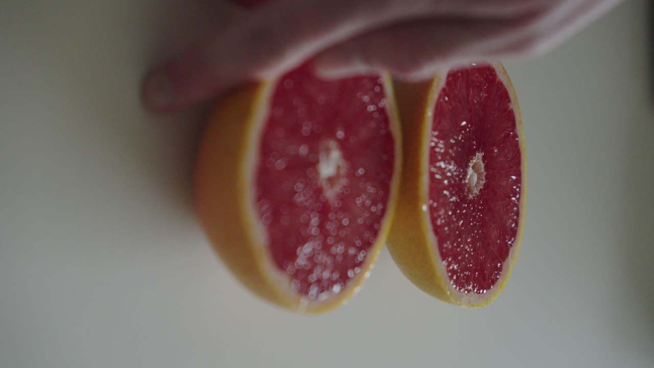 Flipping a half of a juicy grapefruit