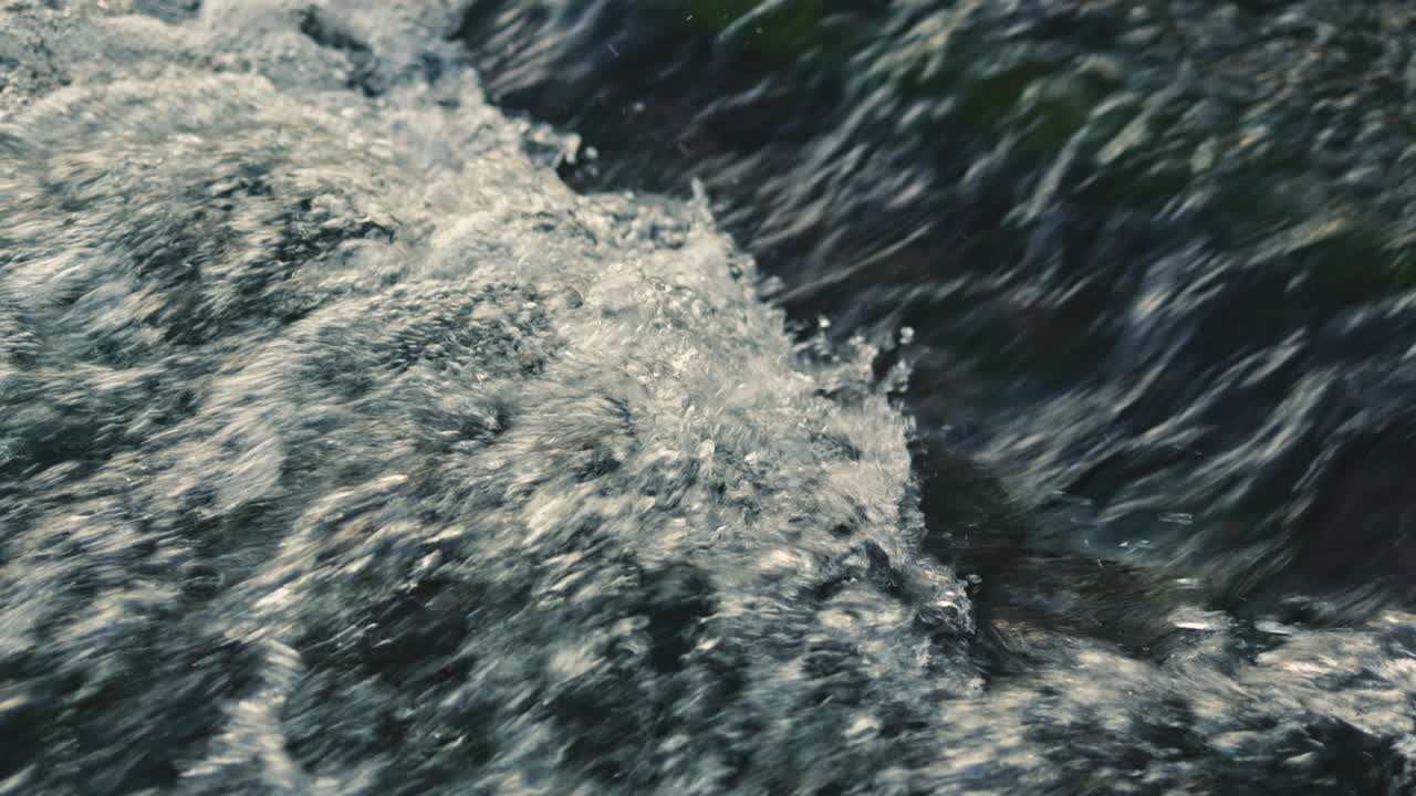 Flusso d'acqua da una sorgente. Forte corrente di acqua di fiume. Flusso d'acqua sui sassi in un fiume