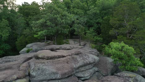 drone ascending from rocky cliff revealing forestry landscape