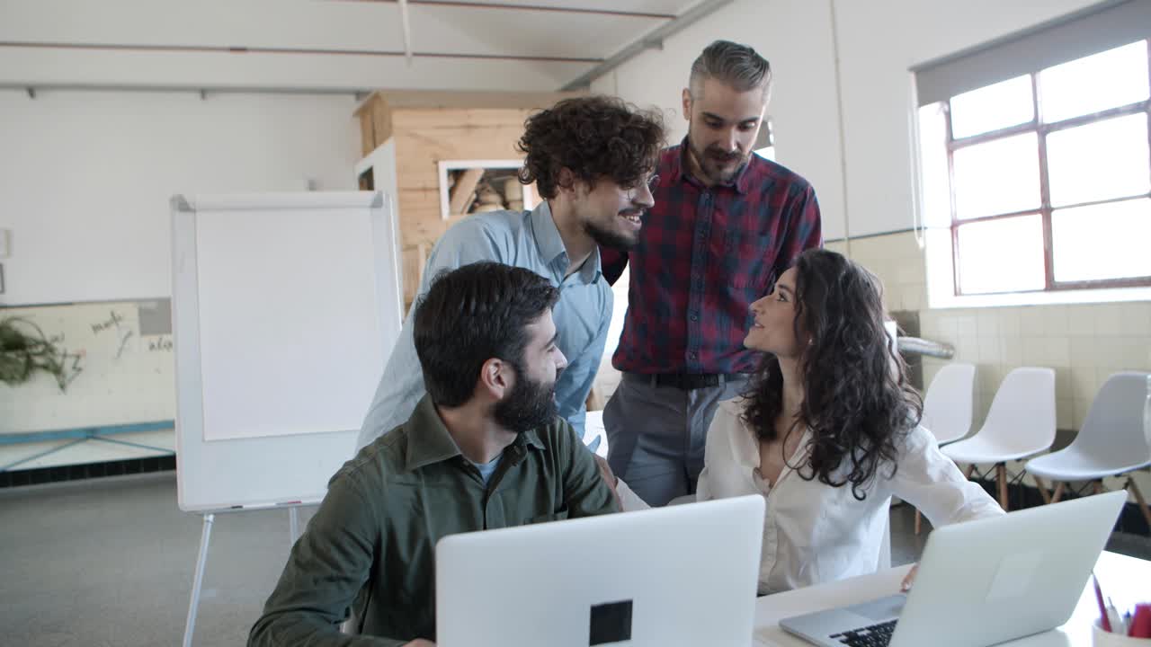 joven gerente barbudo y rizado reuniéndose con sus compañeros de trabajo en la oficina