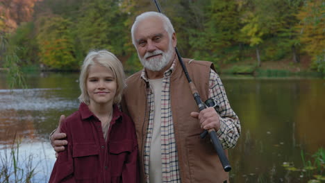 grandfather and grandson fishing by the lake in autumn