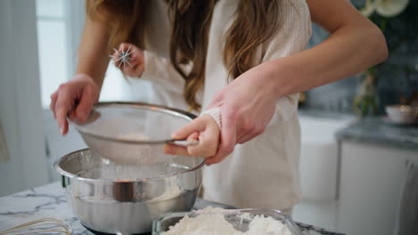 las manos de la madre y la hija cocinando la masa en casa de cerca. el bebé haciendo comida con la madre