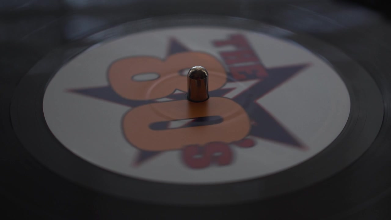 Vinyl Record With 1980's Hits Compilation, Spinning on Turntable, Close Up