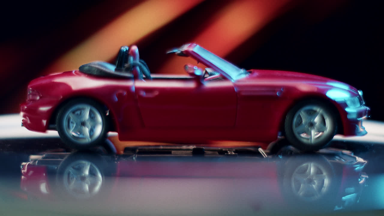 Red Toy Convertible Car on Reflective Surface