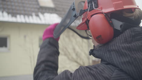 primer plano de una mujer que lleva un casco duro con visera para protección