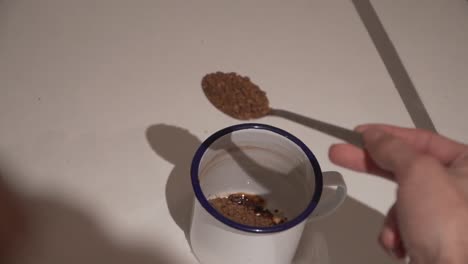 over the shoulder shot of instant coffee being poured into mug