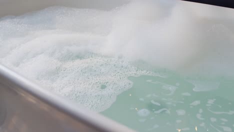 african american woman getting into bath with one leg in bathroom