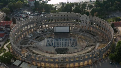 Aerial-dolly-shot-pulling-back-from-the-Pula-Arena-in-Pula,-Croatia-late-in-the-afternoon