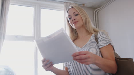 female first time buyer looking at house survey in room to be renovated