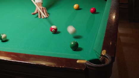 playing american billiard poule close-up. colorful balls on green billiards table .billiard balls with numbers on a pool table. billiards team sport. high quality 4k footage