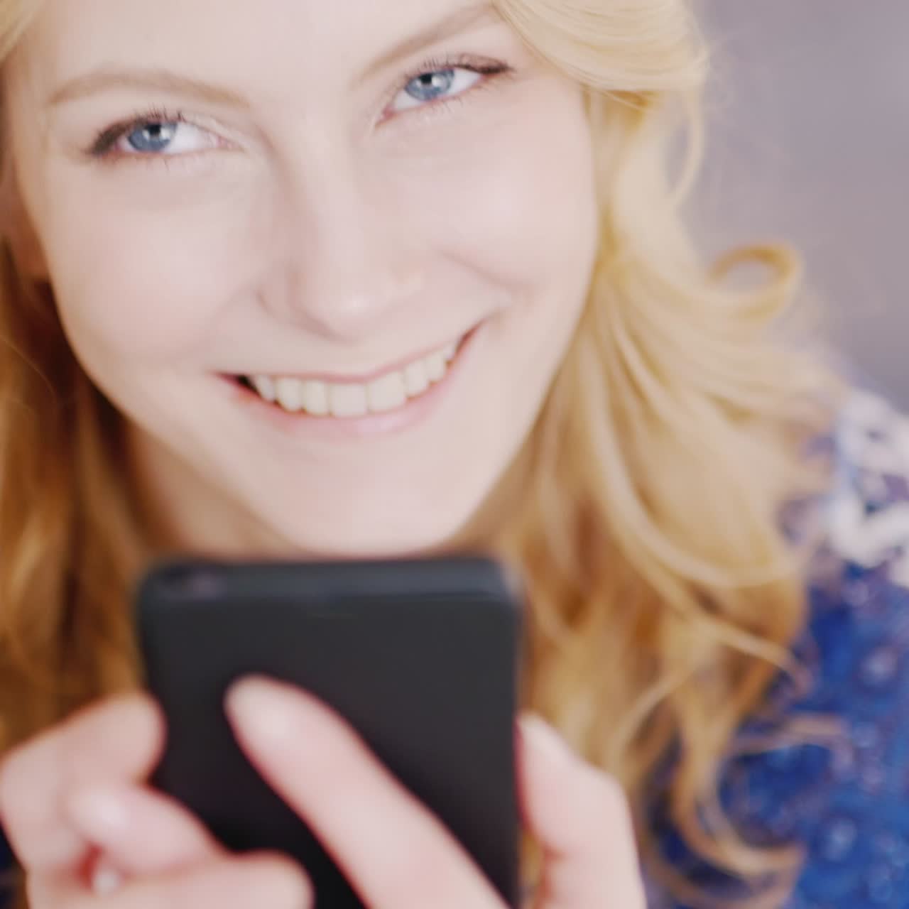 Giovane donna che digita un messaggio su uno smartphone