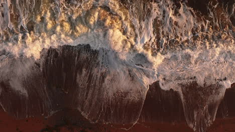 Vista-Aérea-En-Cámara-Lenta-De-Olas-Rompiendo-En-Una-Playa-Al-Atardecer