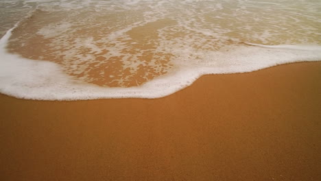 ocean wave on sandy beach.