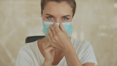 portrait. young sporty woman puts on face mask looking at camera in the gym. close-up.