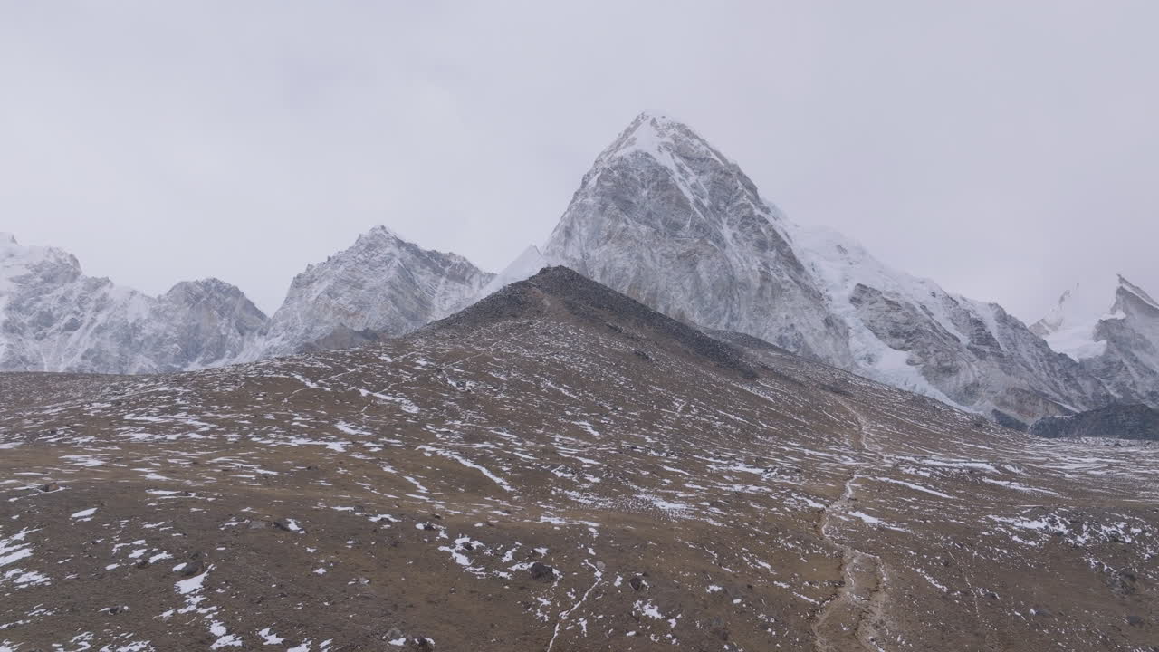 Aerial view of Mount Pumori and Kalapatthar View Point at Everest Base Camp trek. Gloomy skies, less snowfall, dry Hindukush Himalaya landscape with trekking trails highlight climate concerns in Nepal